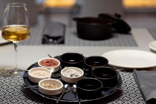 a black plate with bowls of food and a glass of wine at Hotel Nestos in Omiš