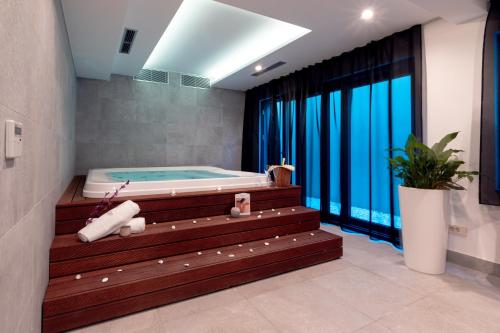 une salle de bains avec un jacuzzi à côté d'une fenêtre dans l'établissement Hotel Nestos, à Omiš