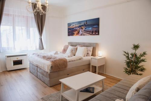 un soggiorno con letto e divano di Heart of Pécs apartman free parking a Pécs