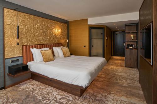 a bedroom with a bed and a dresser at Alexander Hotel in Noordwijk aan Zee