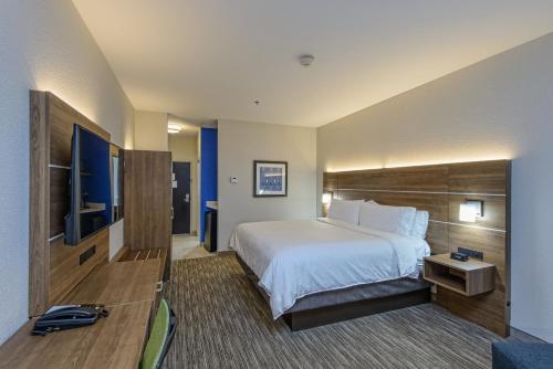 a hotel room with a bed and a flat screen tv at Holiday Inn Express & Suites Corpus Christi by IHG in Corpus Christi
