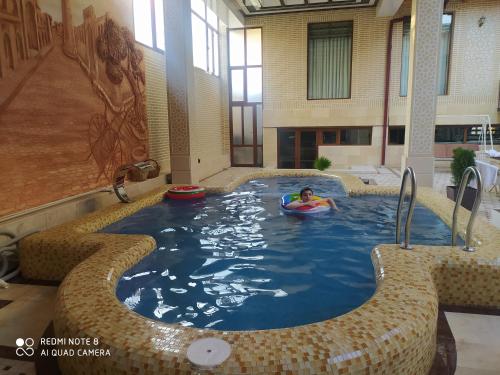 a person in a pool in a building at Hotel Shams in Bukhara