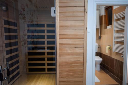 ペーチにあるHeart of Pécs apartman free parkingのバスルーム(トイレに向かう木製のドア付)