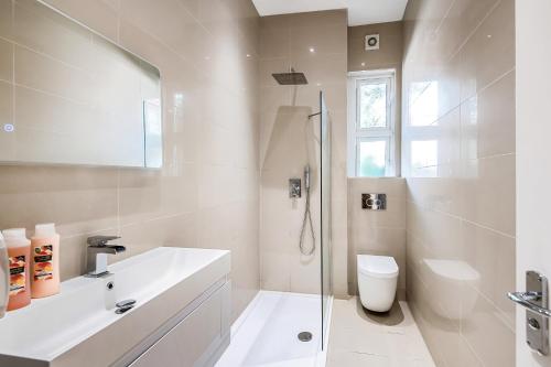 a white bathroom with a sink and a toilet at Modern and light 2 bed flat in SW2 in London