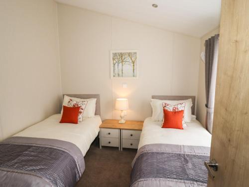 two twin beds in a room with a table at Seagull Lodge in Runswick