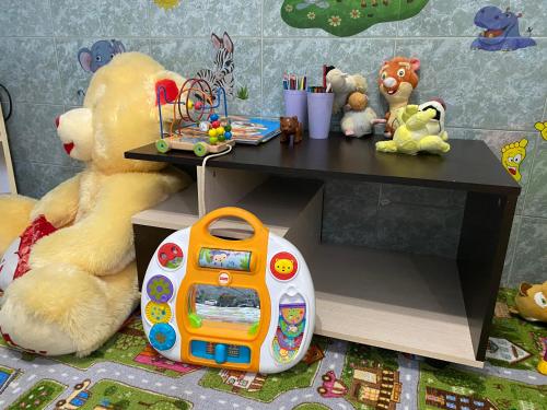 misia siedzącego obok stołu z zabawkami w obiekcie Гостевой дом "Маячок" w mieście Gelendżyk