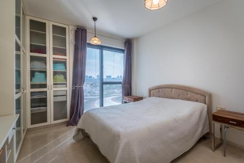 - une chambre avec un lit et une grande fenêtre dans l'établissement Front of Beach next Ritz Hotel - 3 Bedroom& 3 Bathroom, à Herzliya