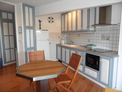 une petite cuisine avec une table et deux chaises dans l'établissement REF 005 Studio pour deux personnes avec terrasse résidence avec piscine PORT CROUESTY ARZON, à Arzon