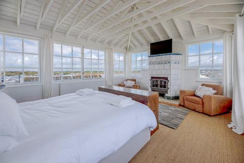 una camera con un grande letto e un camino di The Boathouse in Felixstowe Ferry - Stunning Waterfront Property a Felixstowe