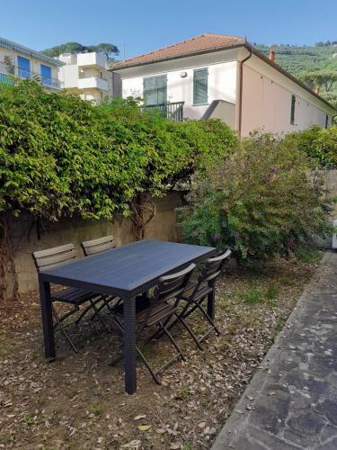 una mesa de picnic negra y sillas frente a un edificio en Tigullio Vacations - Flavia beach apartment, en Lavagna