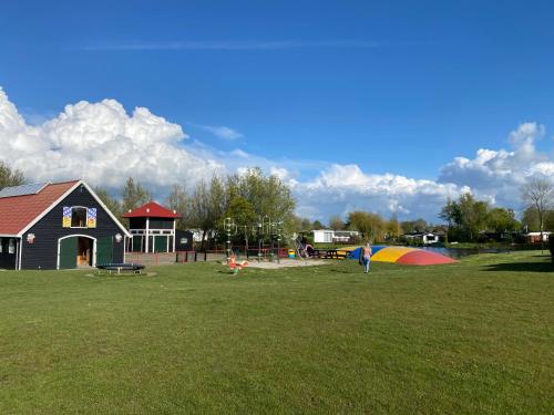 a person is flying a kite in a park at Vakantiehuisje Makkum NL - S15 in Makkum