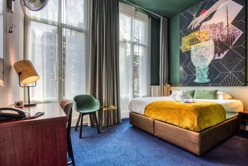 a bedroom with a bed and a desk and a window at Hotel Alexander in Amsterdam