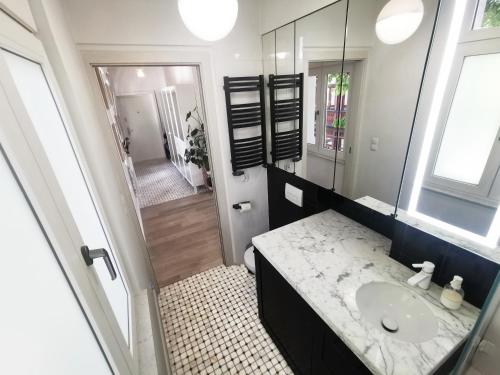 ein Bad mit einem Waschbecken und einem Spiegel in der Unterkunft Retro Apartment in Sopot Center in Sopot