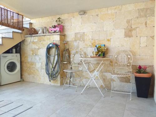 a laundry room with chairs and a washing machine at Apartments Panda in Bol