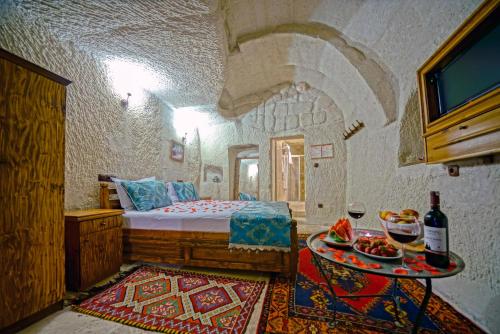 a bedroom with a bed and a table with food on it at Elysee Cave House in Göreme