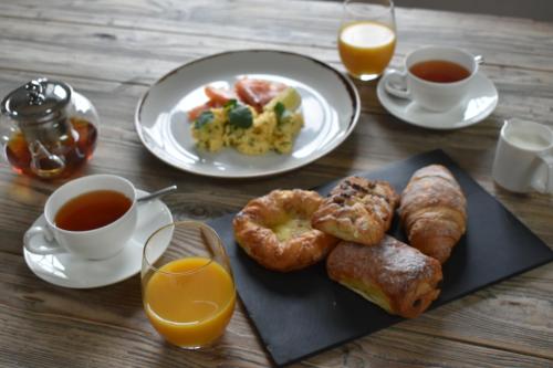 a table with a plate of breakfast food and two cups of orange juice at The Merchant's Yard in Tideswell