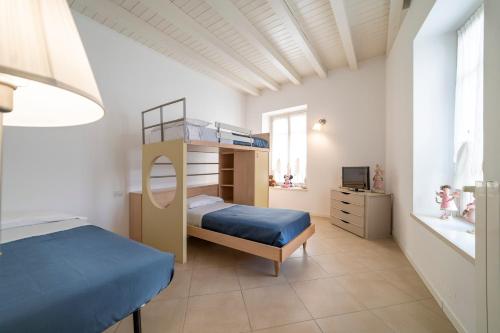 a bedroom with a bunk bed with a blue bedspread at Albergo Diffuso Vulcano Village in Castro