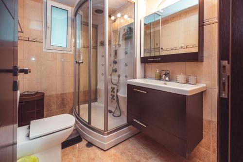 y baño con ducha, aseo y lavamanos. en Villa Mika Near Ialysos Beach en Ialyssos