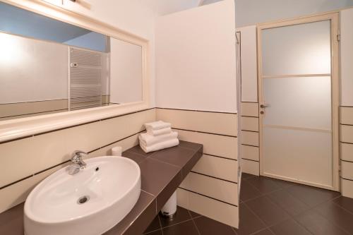 a white bathroom with a sink and a mirror at Albergo Diffuso Vulcano Village in Castro
