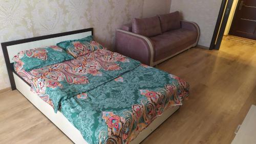 クルスクにあるFlat on Klykova 92のベッドルーム1室(ベッド1台、椅子、ソファ付)
