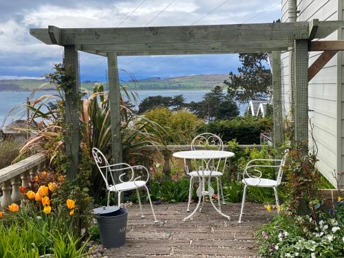 een tafel en stoelen op een patio met een pergola bij Haylie Hotel in Largs