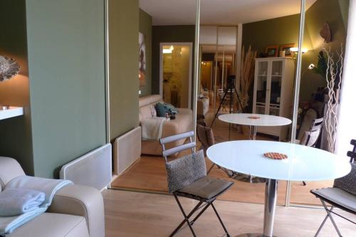 - un salon avec deux tables et un canapé dans l'établissement Nid Douillet à Bagatelle, à Deauville