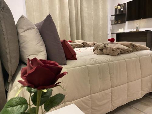 a bed with pillows and a red rose in a room at MAD SUITES & APARTMENTS in Bernalda