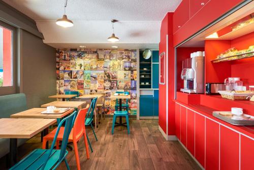 un restaurant avec des tables, des chaises et des murs rouges dans l'établissement hotelF1 Dijon Nord, à Dijon