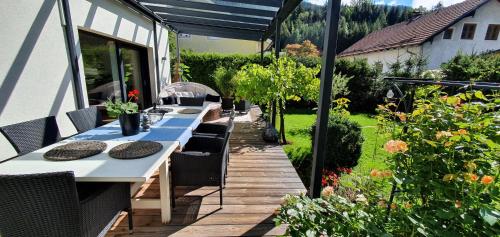 a patio with a long table and chairs in a garden at Jagd trifft Moderne & Boutique Jardin Ferienhaus in Annaberg im Lammertal