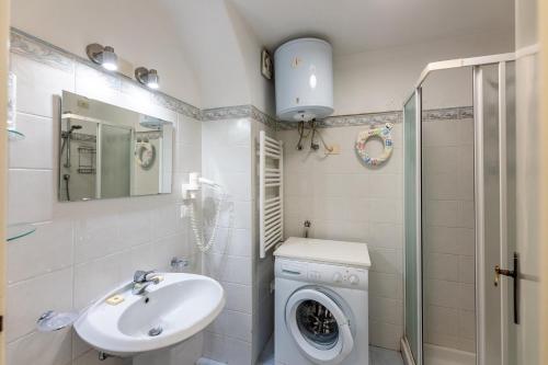 uma casa de banho com uma máquina de lavar roupa e um lavatório em Le Casasse "Grecale" em Varigotti