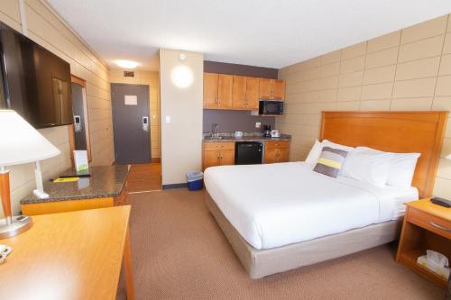 Кровать или кровати в номере Neighbourhood Inn Hotels in Bonnyville