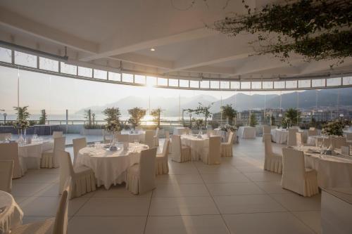 サレルノにあるグランド ホテル サレルノの白いテーブルと椅子が備わる宴会場