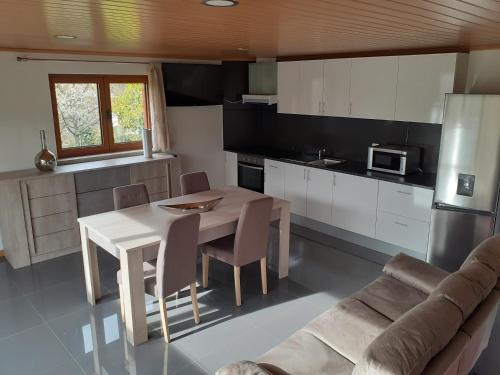 a kitchen and dining room with a table and a couch at Casa Mota Pinto in Castro Daire