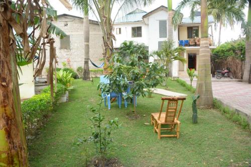 a yard with chairs and a table and trees at JJ & JE Family House in Dar es Salaam