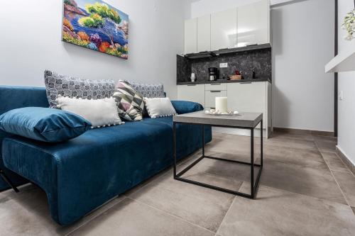 a blue couch in a living room with a table at Halkidiki beach apartments 1 Nea Kallikratia Vergia beach in Nea Kalikratia
