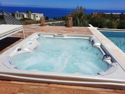 a jacuzzi tub sitting on a deck next to a pool at Thea Sunrise Luxury Villa with Heated Eco Pool in Kallithea Rhodes