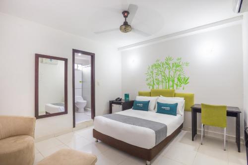 a bedroom with a bed and a desk and a mirror at Ayenda Casa Real in Montería