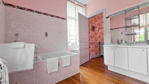 a pink bathroom with a tub and a sink at Le Moulin de Francueil in Francueil