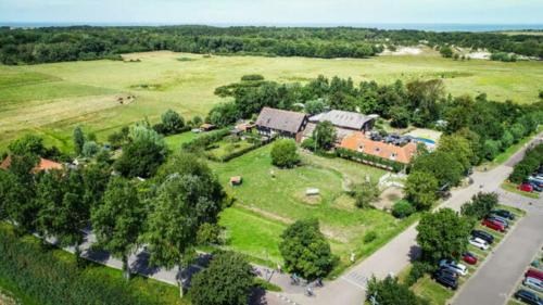 une vue aérienne sur une maison dans un champ arboré dans l'établissement Holidayhome - Kon Emmaweg 26 - Vrouwenpolder - Uitspanning Oranjezon, à Vrouwenpolder