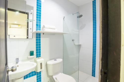 ein Badezimmer mit einem weißen WC und einem Waschbecken in der Unterkunft Ayenda Casa Real in Montería