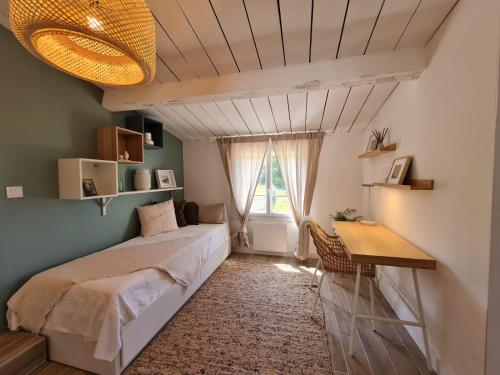 a bedroom with a bed and a desk and a window at Domaine de la Navicelle in Le Pradet