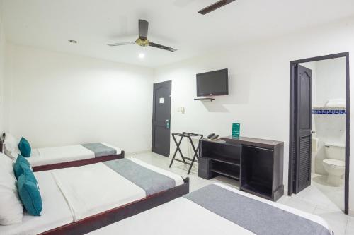 a hotel room with two beds and a television at Ayenda Casa Real in Montería