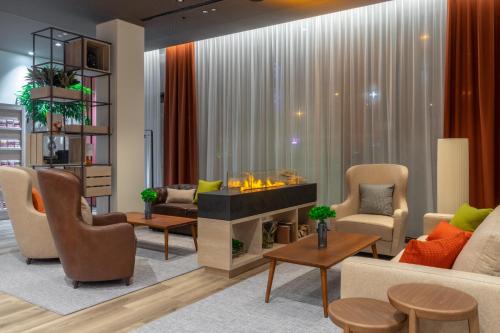 a living room with a fireplace and furniture at IntercityHotel Budapest in Budapest