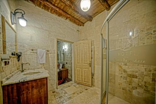 a bathroom with a shower and a sink and a mirror at Elysee Cave House in Goreme