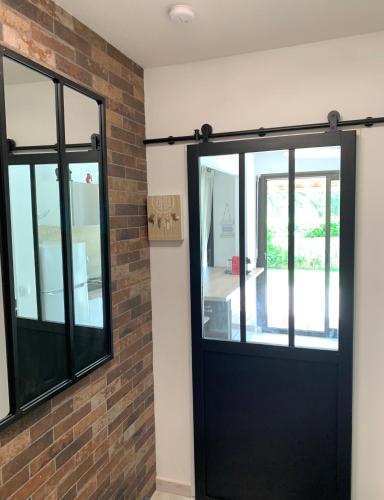 a black door in a room with a brick wall at Magnifique T2 avec terrasse et Jardin privé in Mandelieu-la-Napoule