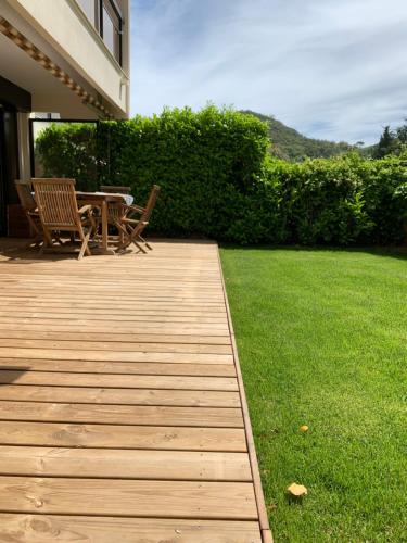 a wooden deck with a table and chairs in a yard at Magnifique T2 avec terrasse et Jardin privé in Mandelieu-la-Napoule