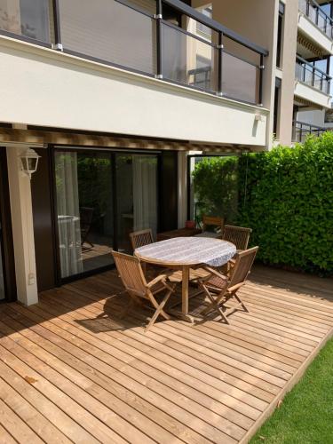 a wooden deck with a table and chairs on it at Magnifique T2 avec terrasse et Jardin privé in Mandelieu-la-Napoule