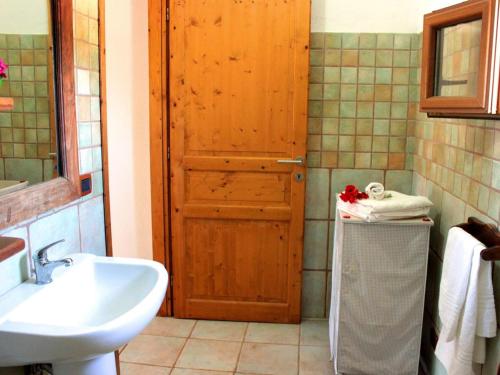 a bathroom with a sink and a wooden door at d Pietraia 13B Trilo in Badesi