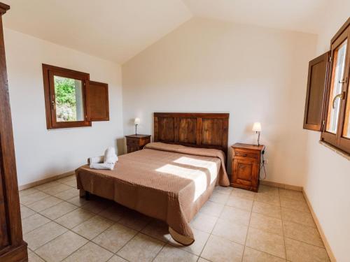 una camera con un letto e due comodini e due finestre di c Scalitti 10C Bilo a Badesi