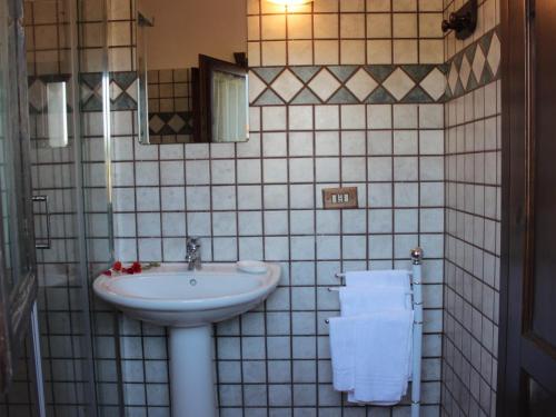 a bathroom with a sink and a mirror and towels at d Pietraia 11B Trilo in Badesi